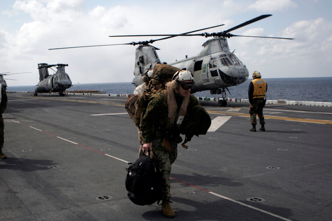 Capt. Paul Bartok, the 31st Marine Expeditionary Unit supply officer, makes his way towards a CH-46E Sea Knight helicopter bound for Japan, March 17. Bartok is part of a group headed to set up the 31st MEU’s forward command element for continued operations in Japan. The 31st MEU continues to prepare for potential humanitarian assistance in support of Operation Tomodachi.  Marines and sailors of the 31st MEU are making preparations for disaster relief efforts after a 9.0 earthquake and subsequent tsunami struck Japan causing widespread damage. The 31st MEU is the nations’ force in readiness in the Asia Pacific region.