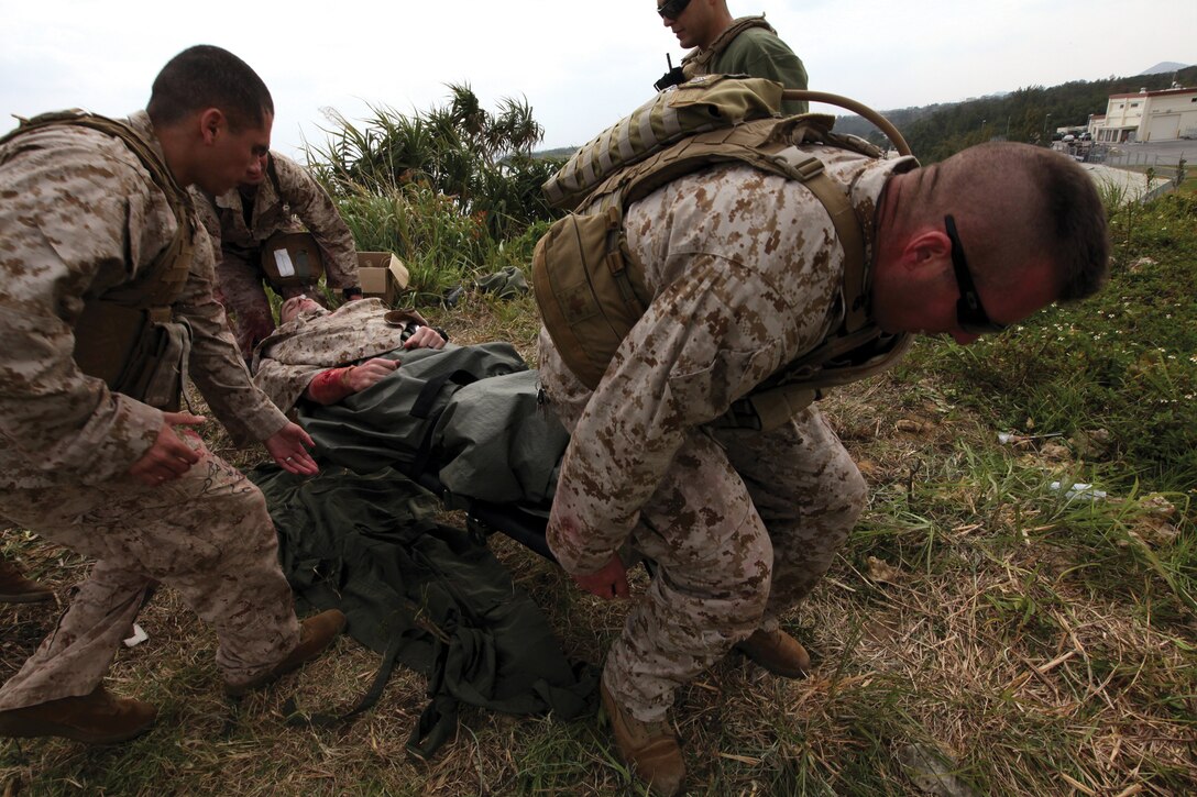 Marines from Military Police Support Company, Headquarters Battalion, 3rd Marine Division, III Marine Expeditionary Force, move a simulated casualty on a stretcher during a  Tactical Combat Casual Care class on Camp Schwab March 17.