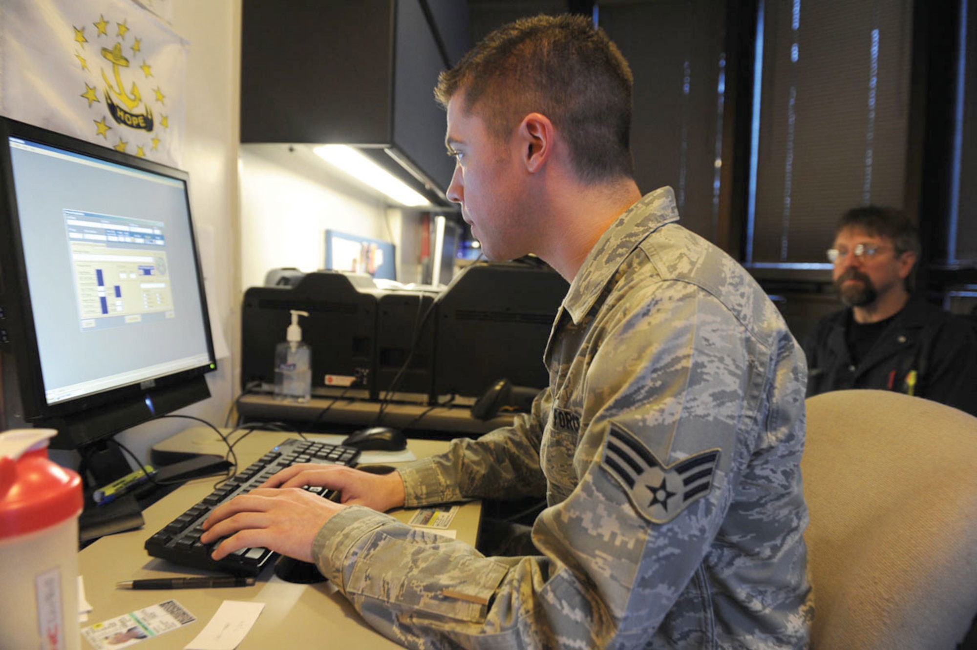 Senior Airman Richard Wright, 673d Security Forces Squadron, Visitor Control Center technician, inputs data for Bruce Jordan, a contractor who requires freqent base access, into the new DBIDS system. (U.S. Air Force photo/Luke Waack)