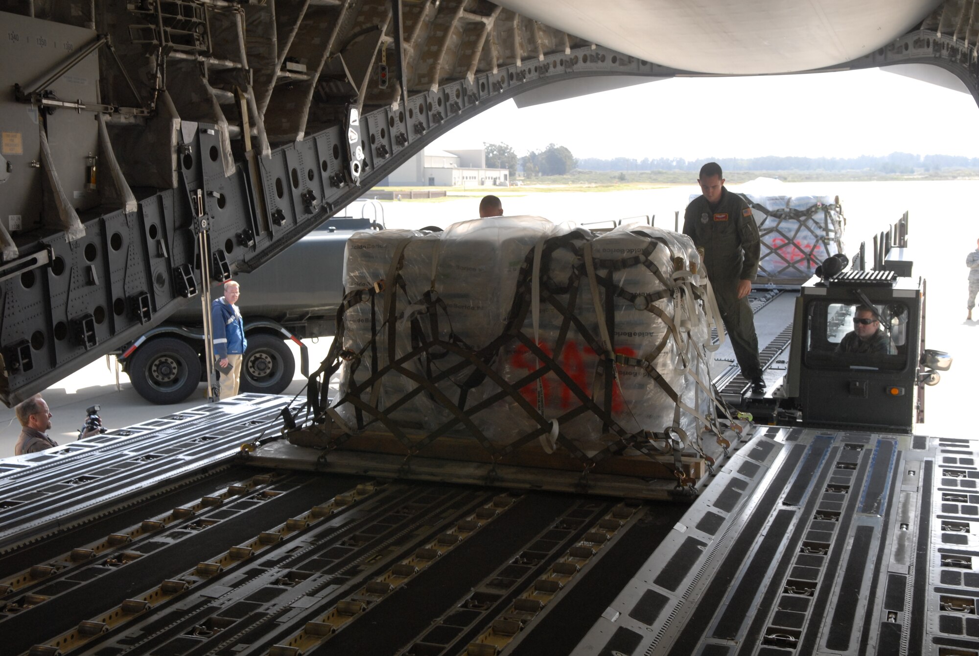 VANDENBERG AIR FORCE BASE, Calif. - Members of the 30th Logistics Readiness Squadron Transportation Management Office, prepare pallets of boric acid for shipment to Japan on Thursday, March 17, 2011. Approximately 34,000 pounds of boric acid from the Diablo Canyon Power Plant is being sent to aid in the cooling of Japan's Fukushima Daiichi Nuclear Complex. Boric acid is used in nuclear power plants to control the fission rate of uranium. (U.S. Air Force photo/ Jerry E. Clemens, Jr.)