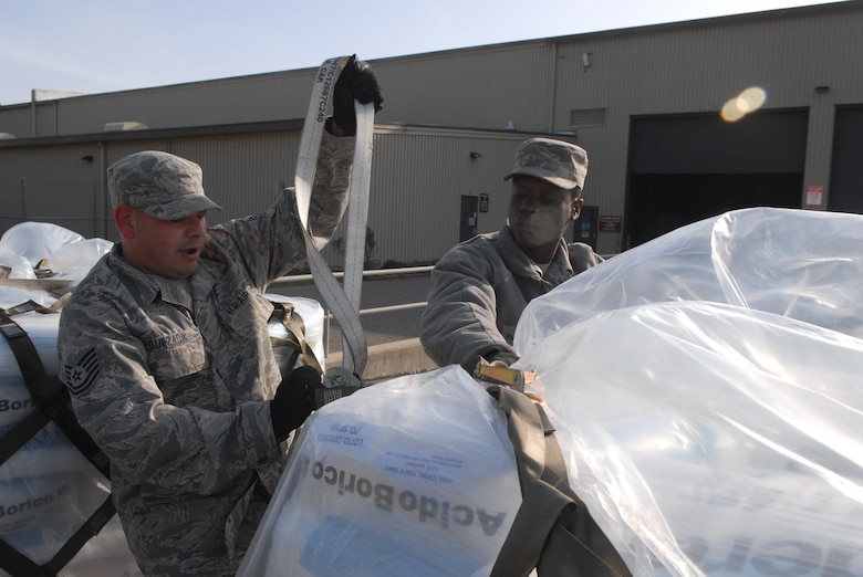 VANDENBERG AIR FORCE BASE, Calif. - Tech. Sgt. Christopher M. Quezada and other members of the 30th Logistics Readiness Squadron Transportation Management Office, prepare a pallet of boric acid for shipment to Japan on Wednesday, March 16, 2011. Approximately 34,000 pounds of boric acid from the Diablo Canyon Power Plant is being sent to aid in the cooling of Japan's Fukushima Daiichi Nuclear Complex. Boric acid is used in nuclear power plants to control the fission rate of uranium. (U.S. Air Force photo/ Jerry E. Clemens, Jr.)