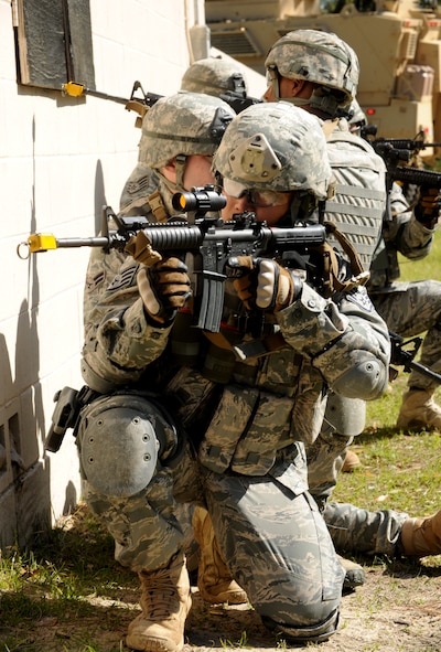 MOODY AIR FORCE BASE, Ga.-- Staff Sgt. Andrew Yu, 823rd Base Defense Squadron fire team leader, aims down his sight as other members of the 823rd BDS demonstrate a village clearing to Leadership Lowndes during a base tour March 17. (U.S. Air Force photo/Airman 1st Class Benjamin Wiseman)(RELEASED)