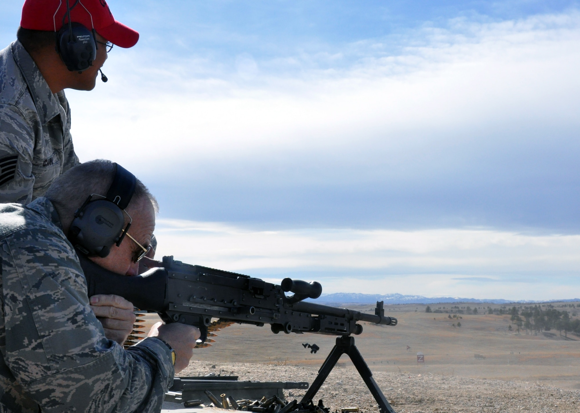 Lt. Gen. Jim Kowalski, Air Force Global Strike Command commander, fires the M-249 light machine gun, with assistance provided by Tech. Sgt. Michael Canne, 90th Ground Combat Training Squadron Combat Arms team leader, on the north firing range of Camp Guernsey, March 14.  The Ground Combat Training Squadron located in Guernsey, Wyo., provides ground combat skills and marksmanship training to ensure people are prepared for a variety of contingency situations. (U.S. Air Force by 1st Lt. Brooke Brzozowske)