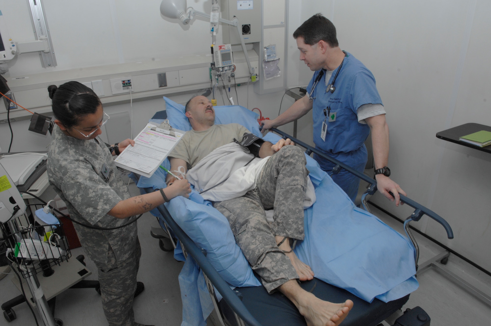 BAGRAM AIRFIELD, Afghanistan -- Senior Airman Diana Plazas Ospina, Craig Joint Theater Hospital medical technician, and Lt. Col. (Dr.) Stephen Galvin, CJTH emergency medicine flight commander, check on Army Sgt. 1st Class George Watson who is a patient in the emergency room. The medical team at the CJTH provide care to Bagram and all forward operating bases in Afghanistan. (U.S. Air Force photo/Senior Airman Amber R. Kelly-Herard)