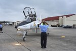 David Jenkins from the 12th Flying Training Wing Maintenance Directorate marshals in the anniversary edition of the T-38 during a ceremony at Randolph March 17.  The ceremony commemorated  the 50th anniversary of the arrival of the T-38 at Randolph. Originally nicknamed the white rocket, the T-38 became the Air Force’s first supersonic jet trainer. The aircraft is used to prepare Air Force pilots for front-line fighter and bomber aircraft such as the F-15E Strike Eagle, B-1B Lancer and F-22 Raptor. The Talon has flown more than 13 million hours and has seen more than 70,000 U.S. Airmen trained.(U.S. Air Force photo/Rich McFadden)