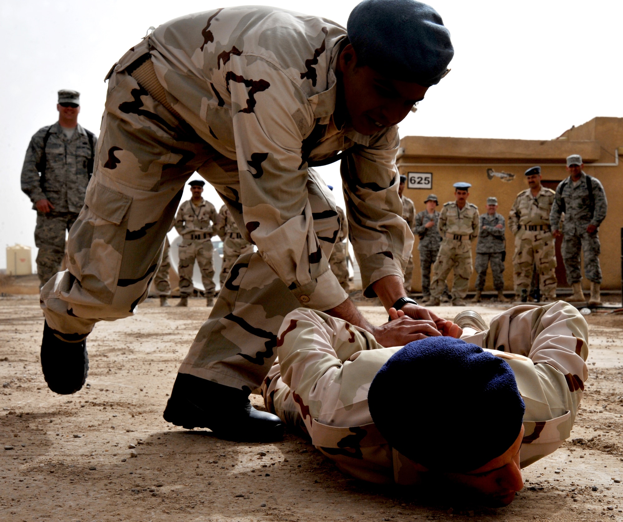 An Iraqi airman apprehends a fellow classmate during a security forces training session held by members of the 407th Expeditionary Security Forces Flight Feb. 21, 2011, at Ali Air Base, Iraq. (U.S. Air Force photo by Senior Airman Andrew Lee/Released)