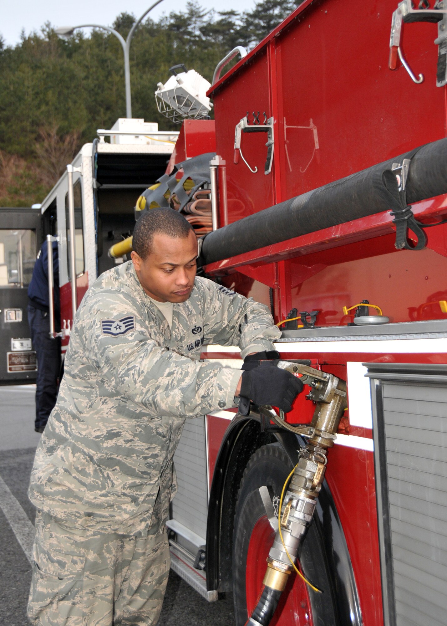Staff Sgt. Larry Gee refuels a fire truck from Yokota Air Base, Japan, to be delivered to firefighters in Fukushima, Japan, March 15, 2011, at a rest stop. The truck will be used to assist in recovery efforts in response to the earthquake and tsunami March 11. Sergeant Gee is firefighter assigned to the 374th Civil Engineer Squadron. (U.S. Air Force/Airman 1st Class Andrea Salazar) 