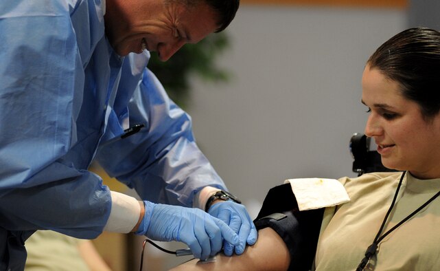 WHITEMAN AIR FORCE BASE, Mo. -- U.S. Army Staff Sgt. Michael Becker, medical lab NCO in charge, draws blood from U.S. Air Force Staff Sgt. Leah Simpson, 13th Bomb Squadron March 17, 2011.  Members of the Armed Services Blood Program drew blood from several donors and ensured a smooth transaction. The blood collected will be used to care for deployed forces. (U.S. Air Force photo by Senior Airman Kenny Holston)(Released)

