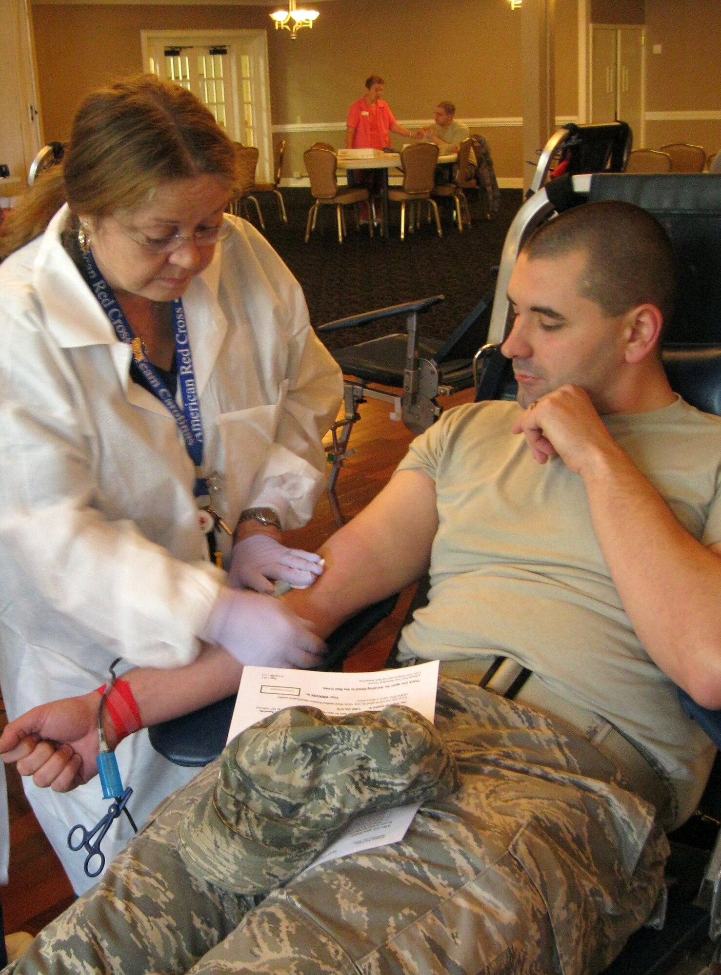 SEYMOUR JOHNSON AIR FORCE BASE, N.C. -- Linda Bain clamps Airman 1st Class James Miller's blood donation line during an American Red Cross blood drive here March 11, 2011. Airman Miller started donating blood when he turned 18 years old. Airman Miller, 4th Comptroller Squadron cashier, is a native of Sylvester, Ga. Ms. Bain is an ARC blood collection technician. (U.S. Air Force photo/Tech. Sgt. Tammie Moore) (RELEASED)