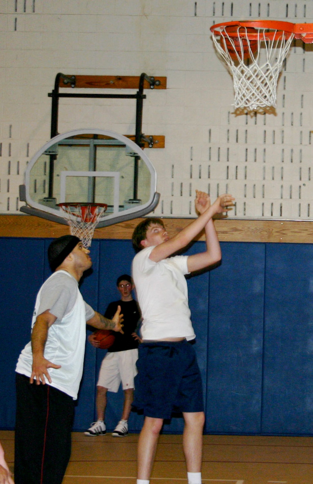 Staff Sgt. Scott Roy (left), flight chief from 66th Security Forces Squadron, instructs youths attending Operation Night Hoops at the Youth Center. Sergeant Roy serves as a coach and mentor, while building a strong rapport with the teens during the weekly event. (Courtesy photo)