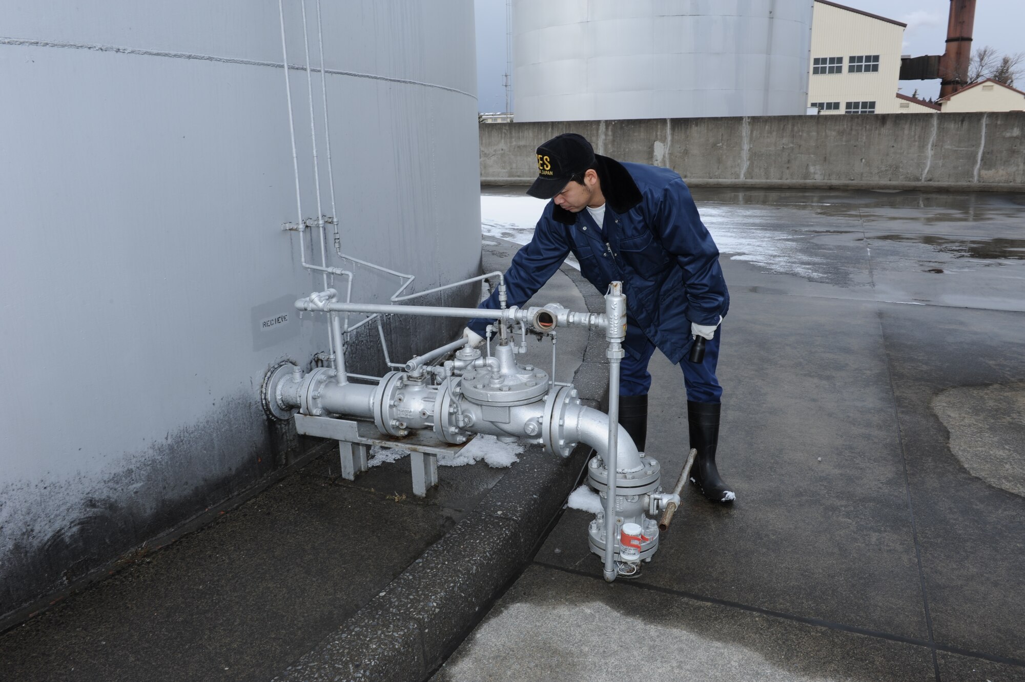 MISAWA AIR BASE, Japan – Ogasawara Hideyuki, 35th Civil Engineer Squadron, inspects the pipe that receives diesel fuel from the fuel storage yard on Misawa Air Base Mar. 17. The inspection consists of checking for damages, such as any cracks or leaks.  (U.S. Air Force Tech. Sgt. Russell J. McBride\Released)