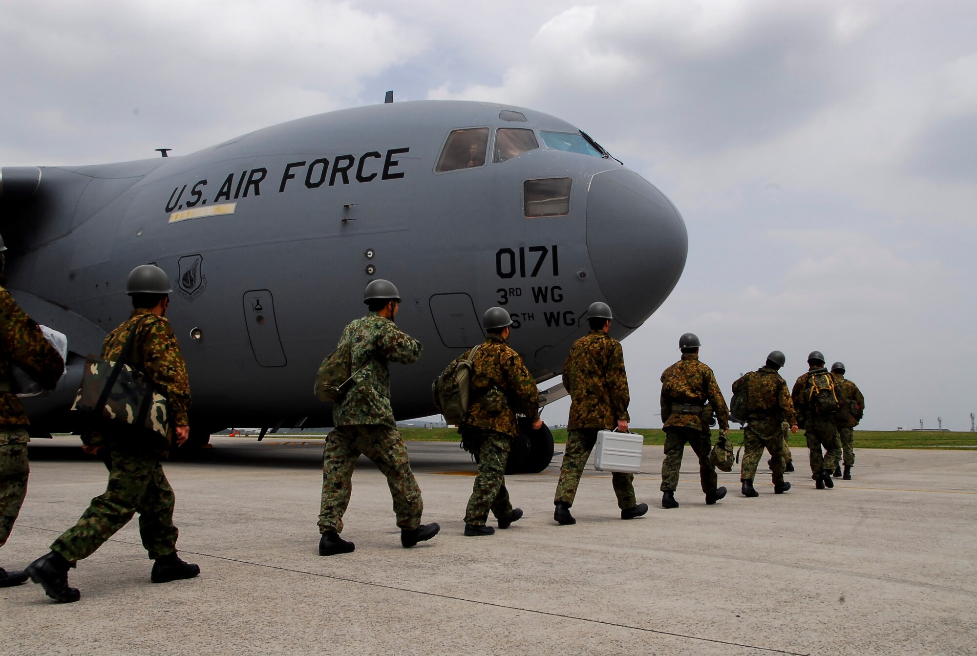 Members of the 15th Brigade, Japan Ground Self Defense Force board a Joint Base Elmendorf-Richardson C-17 Globemaster III on Kadena’s flight line, March 17. Kadena Airmen worked with the JBER crew to transport the JGSDF team and four trucks full of supplies to aid the earthquake and tsunami victims in mainland Japan. (U.S. Air Force photo/Airman 1st Class Maeson L. Elleman)