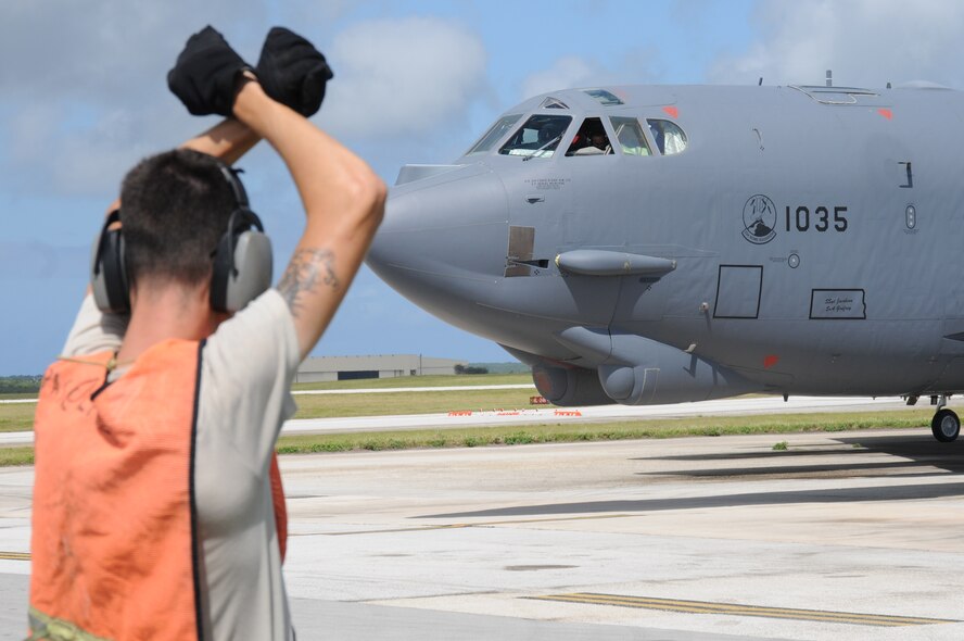 ANDERSEN AIR FORCE BASE, Guam- Airman 1st Class Justin Palmer, 69th Expeditionary Aircraft Maintenance Squadron crew chief, Minot Air Force Base, N.D., marshals out a B-52 Stratofortress to taxi take-off, March 14. The B-52 along with two other B-52's will be completing a training mission north of Guam along with in-air refueling and radar scenarios. (U.S. Air Force photo/ Senior Airman Carlin Leslie)