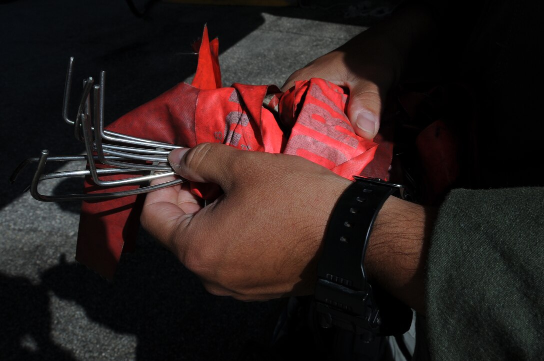 ANDERSEN AIR FORCE BASE, Guam- A member of the 69th Expeditionary Bomb Squadron from Minot Air Force Base, N.D., counts 'remove before flight' pins ensuring all are accounted for before takeoff, March 14 here. The pins are inserted at different points in the aircraft, making sure all areas are checked before and after each flight. (U.S. Air Force photo/ Senior Airman Carlin Leslie)