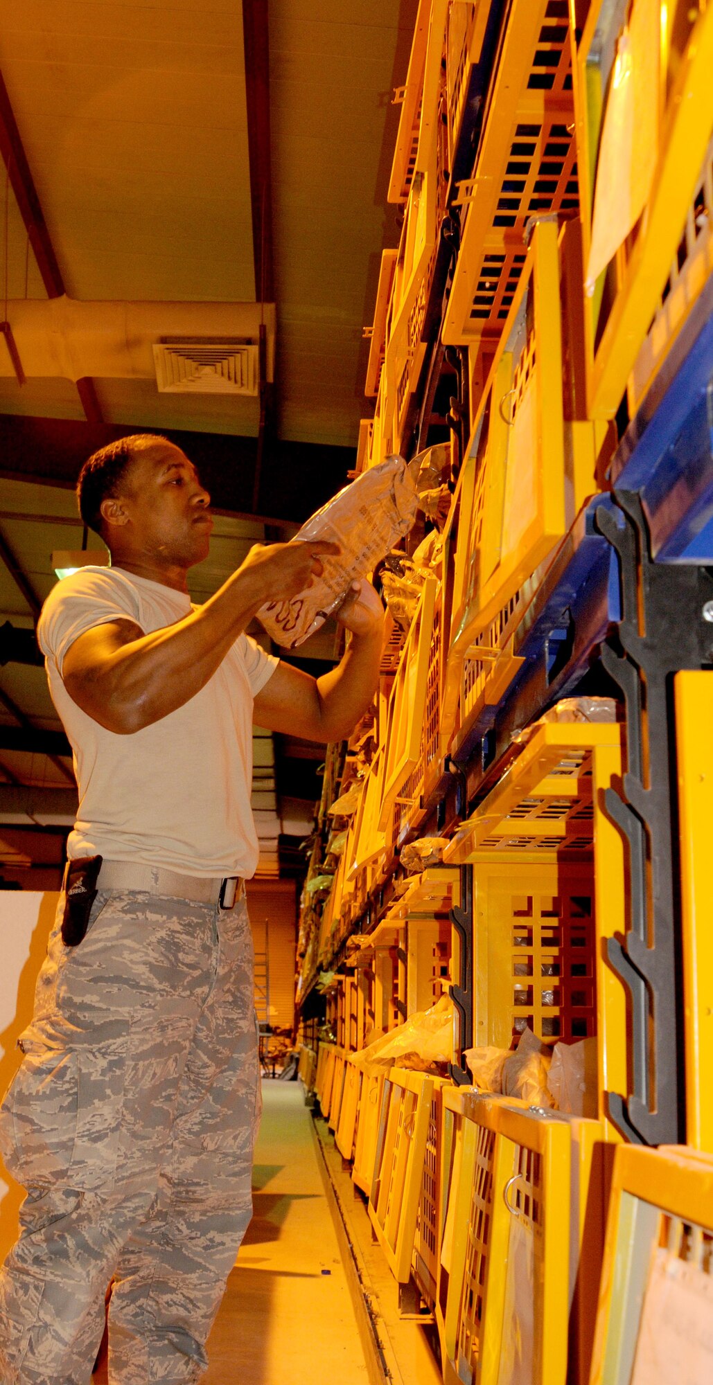 Senior Airman Robert Kelly reshelves chemical protective suits at the 386th Expeditionary Logistics Readiness Squadron Expeditionary Theater Distribution Center. The ETDC is one of three in the U.S. Air Force's Central Command Area Of Responsibility that provides a one-stop shop for individual body armor, chemical protective gear and weapons courtesy storage for forward deploying and transit members. (U.S. Air Force photo by Staff Sgt. Patrice Clarke)