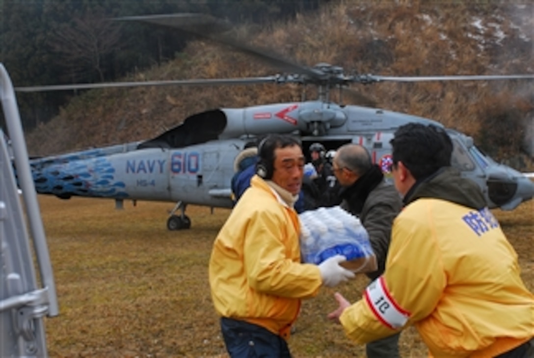 Japanese citizens unload food and water from an HH-60H Sea Hawk helicopter assigned to Helicopter Anti-Submarine Squadron 4 off the coast of Japan on March 16, 2011.  The squadron is embarked aboard the aircraft carrier USS Ronald Reagan (CVN 76) providing humanitarian assistance as directed in support of Operation Tomodachi.  