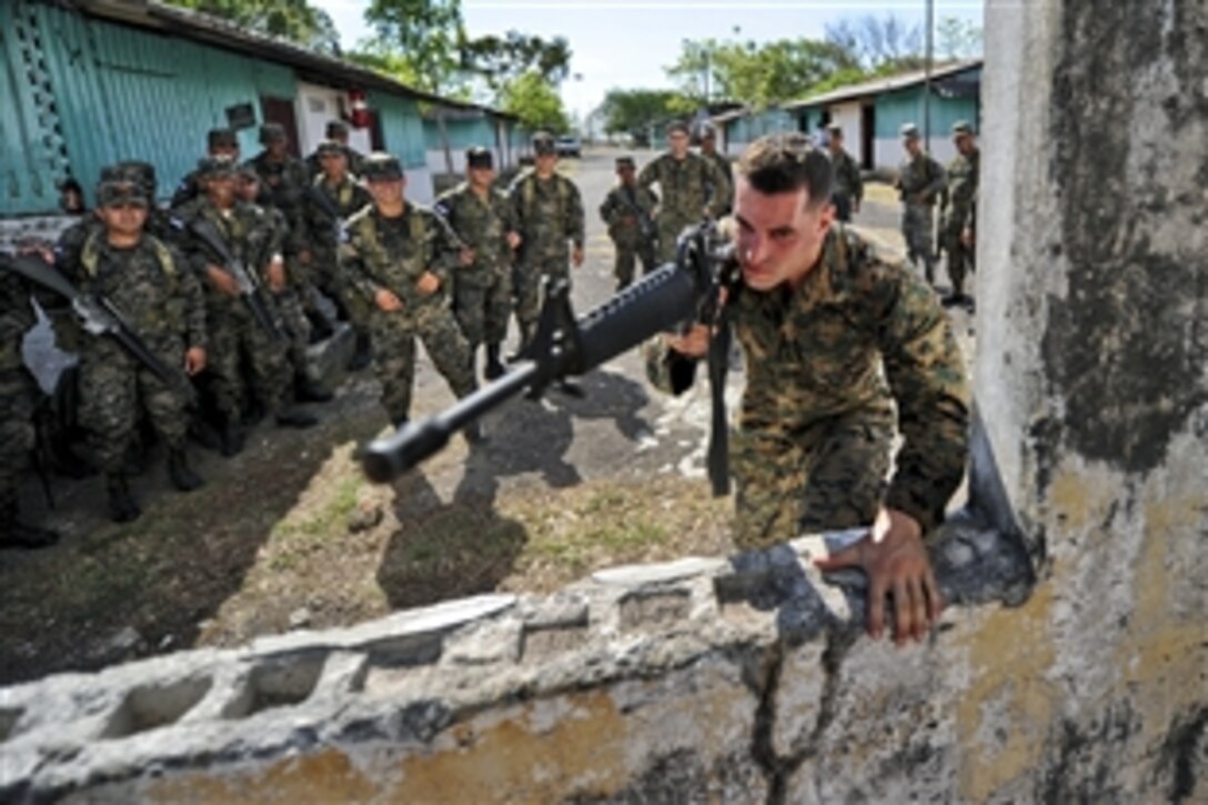 U.S. Marine Corps Sgt. Michael G. Roth demonstrates proper building-entry techniques to Honduran soldiers during a weeklong expert exchange to support Southern Partnership Station in San Lorenzo, Honduras, March 15, 2011. The partnership station is an annual deployment of U.S. ships to the U.S. Southern Command area of responsibility in the Caribbean and Latin America. Roth is assigned to Marine Corps Training and Advisory Group.
