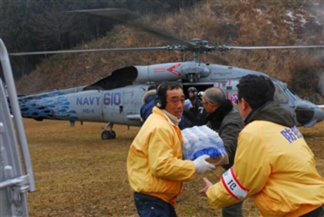 Japanese citizens unload food and water from an HH-60H Sea Hawk helicopter assigned to Helicopter Anti-Submarine Squadron 4 off the coast of Japan on March 16, 2011.  The squadron is embarked aboard the aircraft carrier USS Ronald Reagan (CVN 76) providing humanitarian assistance as directed in support of Operation Tomodachi.  
