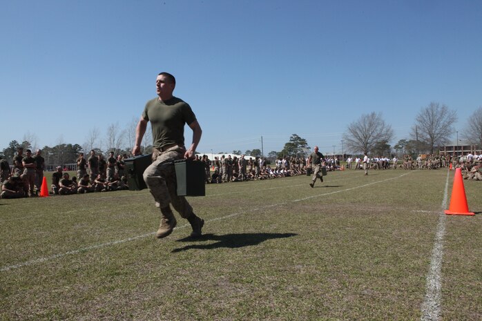 A Marine with the Marine Corps Engineer School, Marine Corps Base Camp Lejeune, sprints while carrying two 40mm grenade ammunition cans during the St. Patrick’s Day celebration on Ellis Field at Courthouse Bay aboard Marine Corps Base Camp Lejeune, March 18. St. Patrick’s Day is celebrated by engineers because he is the patron saint of engineers.