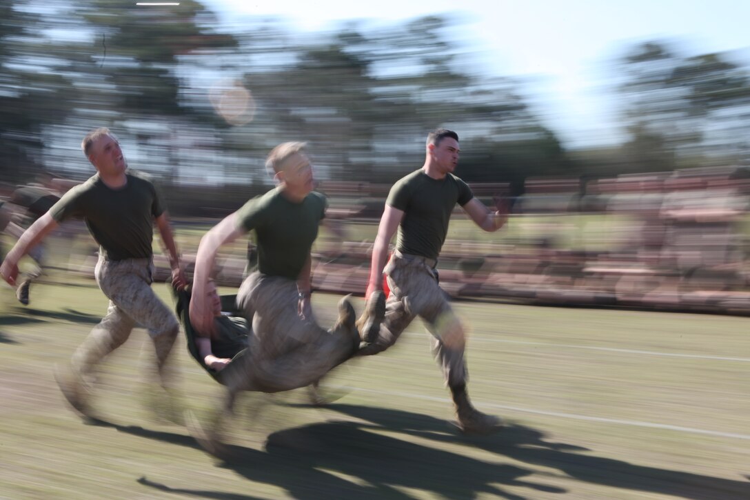 Marines with the Marine Corps Engineer School, Marine Corps Base Camp Lejeune, sprint while carrying a fifth Marine who is laying on a stretcher during the St. Patrick’s Day celebration on Ellis Field at Courthouse Bay aboard Marine Corps Base Camp Lejeune, March 18. St. Patrick’s Day is celebrated by engineers because he is the patron saint of engineers.