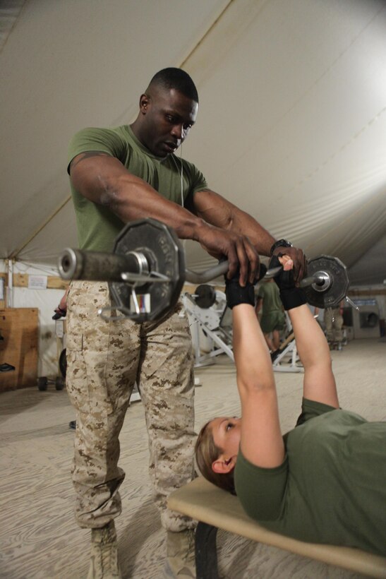 Washington, D.C., native Gunnery Sgt. Michael L. Woods spots one of his many workout buddies and fellow Marines. The information security technician with the Communication and Information Systems section, 2nd Marine Division (Forward), works to keep his Marines both physically and mentally fit to better serve the Marines of 2nd MarDiv (Fwd).