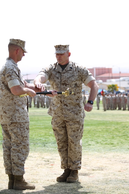 Sgt. Maj. Keith Coombs accepts the non-commissioned officer’s sword from Lt. Col. Todd Simmons, battalion commander, 1st Battalion, 7th Marine Regiment, during a ceremony appointing him the battalion sergeant major at Lance Cpl. Torrey L. Gray Field March 18, 2011.::r::::n::