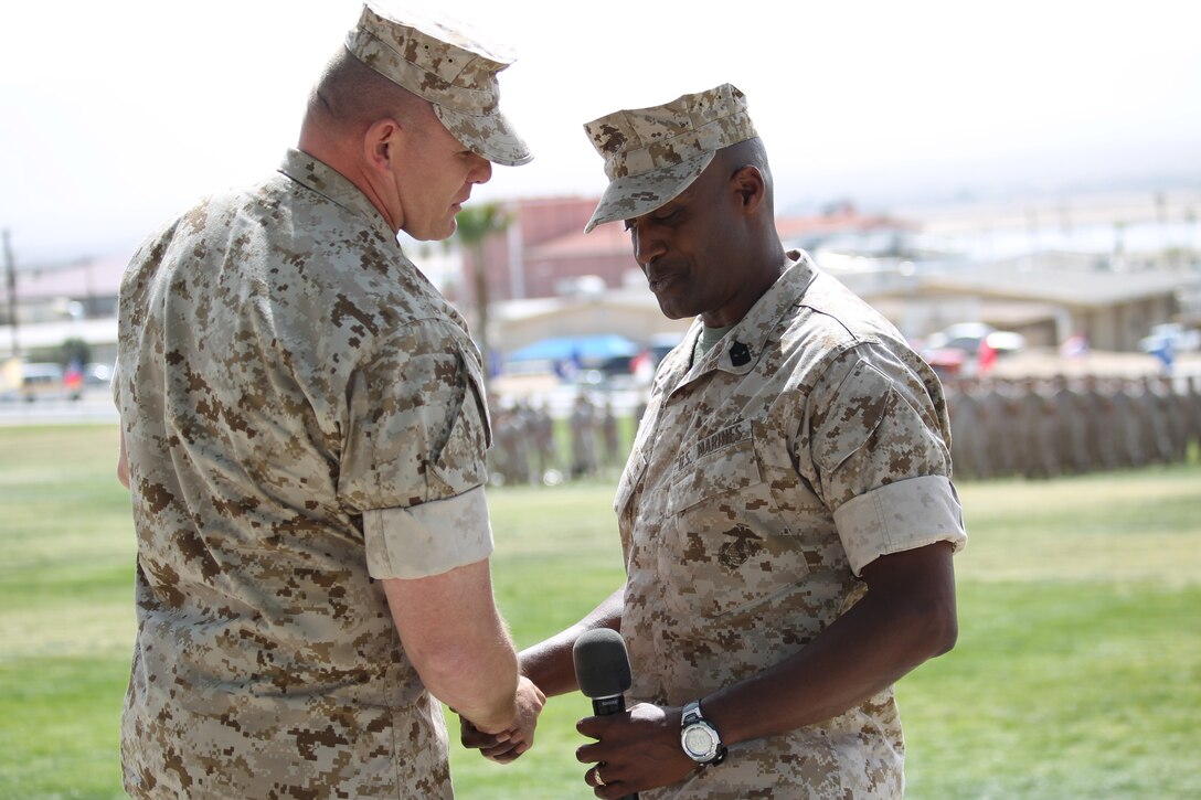 Sgt. Maj. Keith Coombs [left], incoming sergeant major for 1st Battalion, 7th Marines, shakes hands with Sgt. Maj. Paron Lewis, the outgoing sergeant major, during a relief and appointment ceremony at Lance Cpl. Torrey L. Gray Field March 18, 2011.::r::::n::