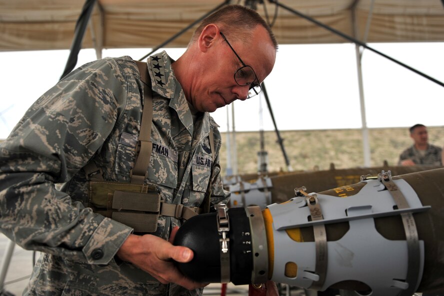 Gen. Donald Hoffman, Air Force Materiel Command commander, installs a nose fuse on a GBU-54 during his visit at the ammunition supply point at Bagram Airfield, Afghanistan, March 18, 2011. General Hoffman received  hands-on training on how to build a live bomb. (U.S. Air Force photo by Senior Airman Sheila deVera)