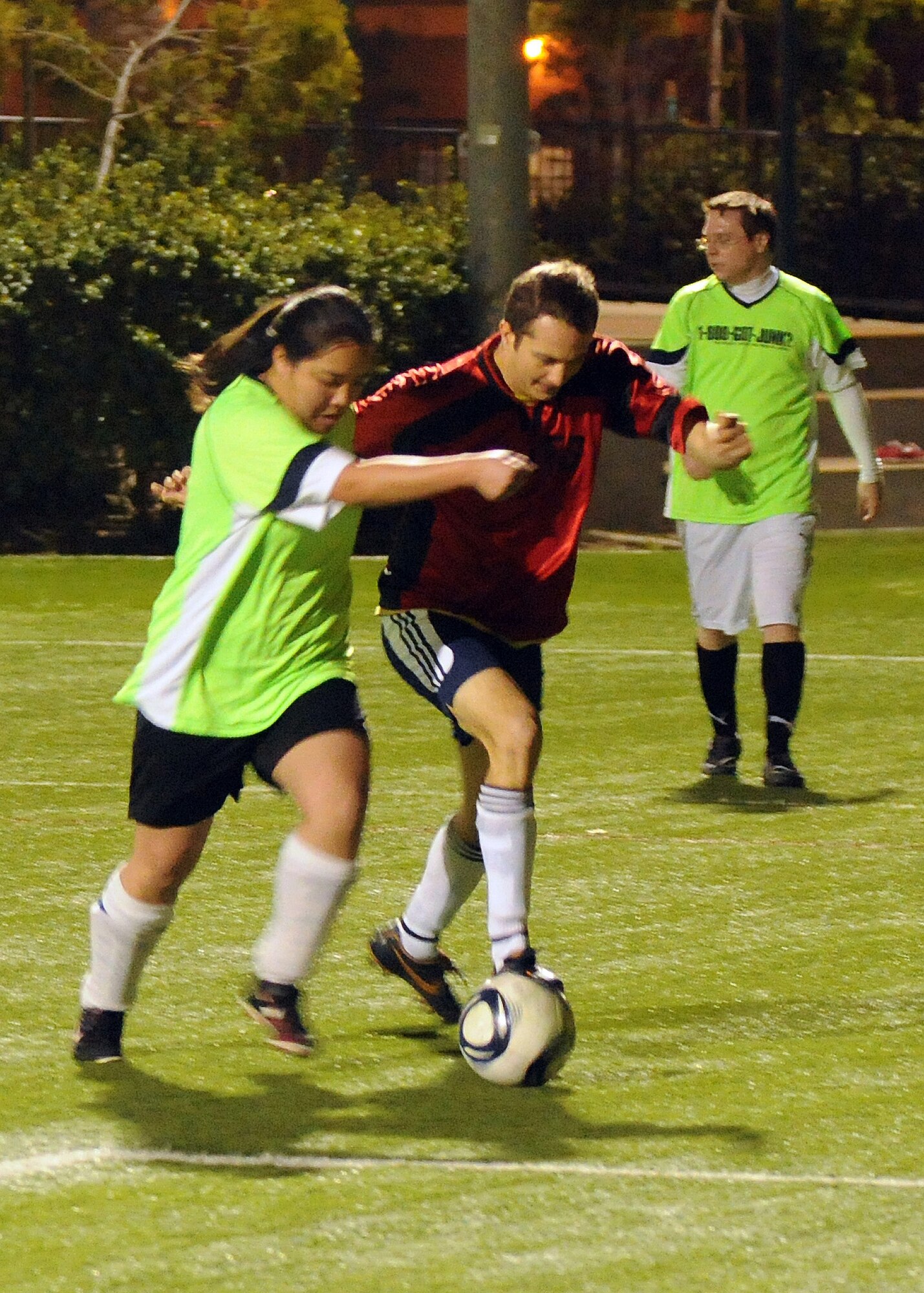 A player from the Los Angeles AFB co-ed soccer team battles a player from the 1-800-GOT-Junk team for control of the ball during a match, March11.  LAAFB won the match 8-3.  (Photo by Jim Gordon)