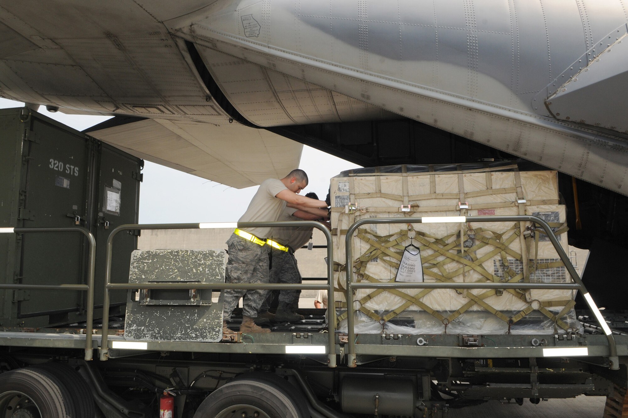 Airmen from the 1st Special Operations Squadron and 733rd Air Mobility Squadron push a pallet into a MC-130H Combat Talon II March 14, 2011, at Kadena Air Base, Japan. The aircraft is delivering additional equipment and support forces for the 353rd Special Operations Group forces deployed supporting humanitarian relief efforts at Yokota Air Base, Japan. (U.S. Air Force photo/Tech. Sgt. Aaron Cram) 