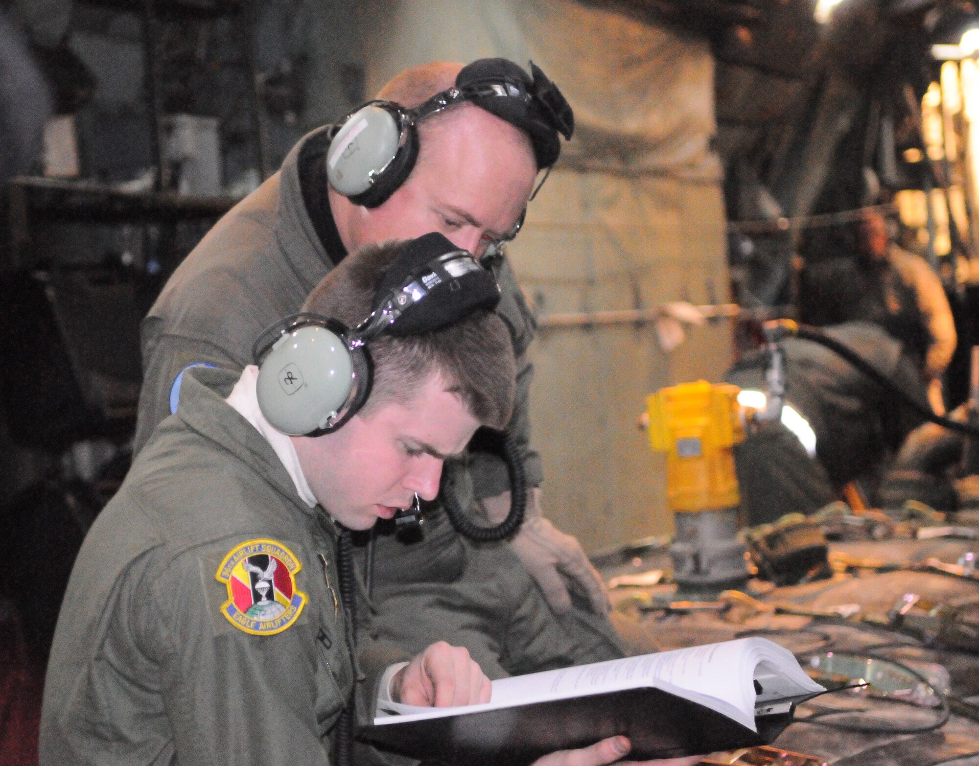 MISAWA AIR BASE, Japan -- Staff Sgt. Jace Hartog, and Airman Bradley Price, 36th Airlift Squadron loadmasters, examine charts to ensure accuracy while delivering fuel to Misawa Air Base here March 18. Yokota delivered 4,700 gallons of fuel to Misawa for use with vehicles, generators and other equipment needed for base operations. (U.S. Air Force photo/Airman 1st Classs Krystal M. Garrett)