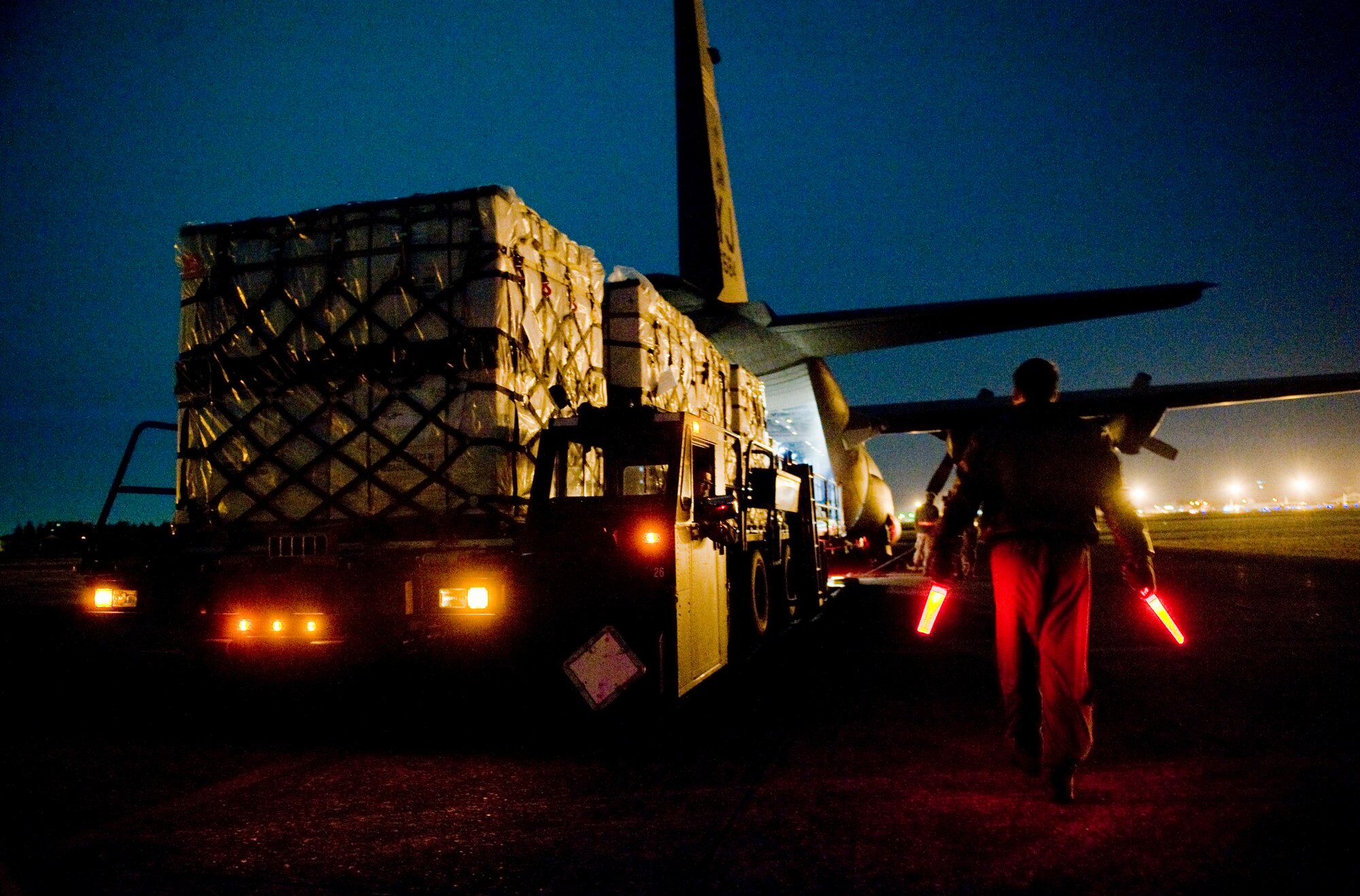 YOKOTA AIR BASE, Japan -- Senior Airman Jason Barbieri, 36th Airlift Squadron, guides a K-loader full of blankets onto a C-130H Hercules here March 18. The 36th Airlift Squadron provided blankets to Sendai Airport in support of Japan's earthquake and tsunami relief effort. (U.S. Air Force photo/Staff Sgt. Jonathan Steffen)