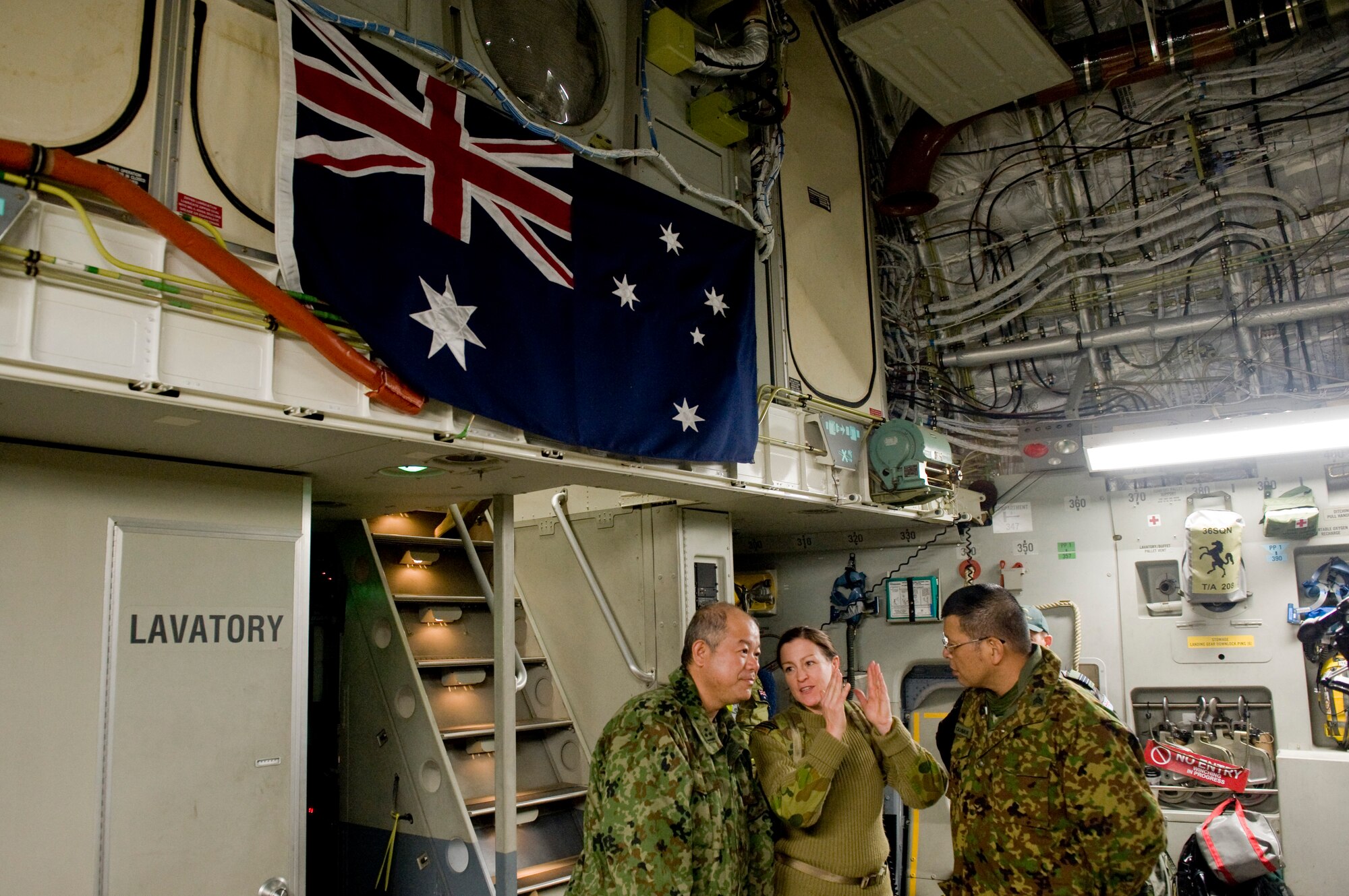 YOKOTA AIR BASE, Japan -- Wing Commander Sonja Halloran, Royal Australian Air Force linguist, talks to Japan Ground Self Defense Force's 15th Brigade members here March 18 on board a C-17 Globemaster III from the 36th Airlift Squadron. RAAF transported the JGSDF 15th Brigade from Okinawa to help with Japan's earthquake and tsunami relief effort. (U.S. Air Force photo/Staff Sgt. Jonathan Steffen)