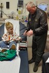 BOARDMAN, Ohio — Air Force Reservist Chief Master Sgt. Davis Kane, a Chief Flight Engineer withthe 910th Airlift Wing helps unwrap a toy C-130 for four-year old Michael Keyes at Akron Children's Hospital of the Mahoning Valley on St. Patrick's Day, March 17.  Chief Kane was one of four Citizen Airmen visitng children at the medical facility.  Dozens of diecast metal C-130 toy airplanes were given to children receiving treatment at the Boardman medical campus.  The toys were funded by the Youngstown Air Reserve-Base Community Council. Michael is a patient at the Boardman campus.  U.S. Air Force Photo/ Maj. Brent Davis