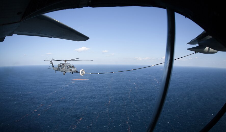 PACIFIC OCEAN -- An MC-130P Combat Shadow from the 17th Special Operations Squadron refuels a HH-60 Pave Hawk helicopter from the 33rd Rescue Squadron March 18. The refueling missions are in support of humanitarian relief operations after an 8.9 magnitude earthquake and following tsunami that rocked Northeastern Japan March 11. (U.S. Air Force photo/Osakabe Yasuo)