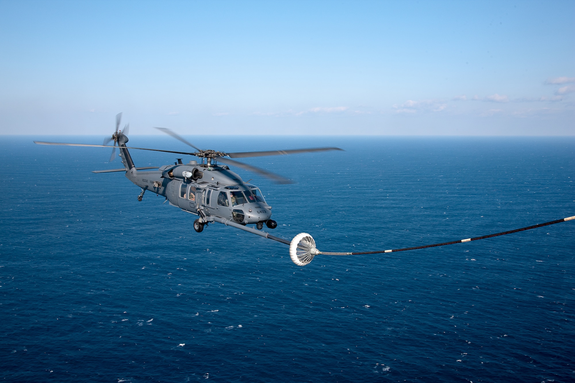 PACIFIC OCEAN -- An MC-130P Combat Shadow from the 17th Special Operations Squadron refuels a HH-60 Pave Hawk helicopter from the 33rd Rescue Squadron March 18. The refueling missions are in support of humanitarian relief operations after an 8.9 magnitude earthquake and following tsunami that rocked Northeastern Japan March 11. (U.S. Air Force photo/Osakabe Yasuo)