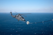 PACIFIC OCEAN -- An MC-130P Combat Shadow from the 17th Special Operations Squadron refuels a HH-60 Pave Hawk helicopter from the 33rd Rescue Squadron March 18. The refueling missions are in support of humanitarian relief operations after an 8.9 magnitude earthquake and following tsunami that rocked Northeastern Japan March 11. (U.S. Air Force photo/Osakabe Yasuo)