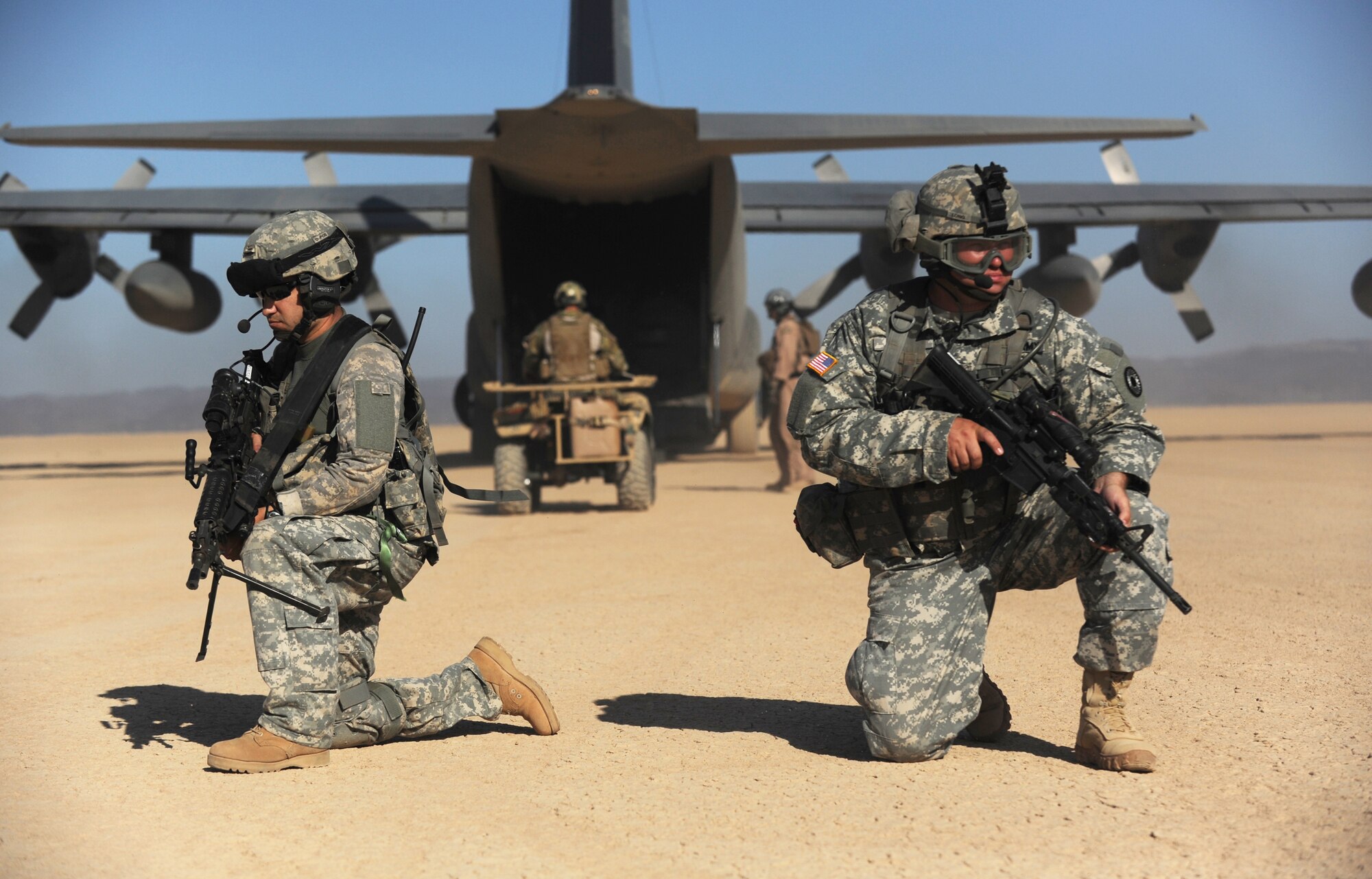 DJIBOUTI--Army Specialist Jason Mosqueda (left) and Sergeant Darel Long, Kansas Army National Guard 2nd Combined Arms Battalion, 137th Infantry Regiment, Joint Combat Search and Rescue, provide security for an HC-130P from the 81st Expeditionary Rescue Squadron during an exercise Feb. 26. The exercise scenario consisted of a personnel recovery task Force of pararescuemen and an Army site security team responding to a downed aircrew, extracting two survivors, and returning them to safety. (U.S. Air Force photo/Master Sgt. Dawn M. Price)

 
