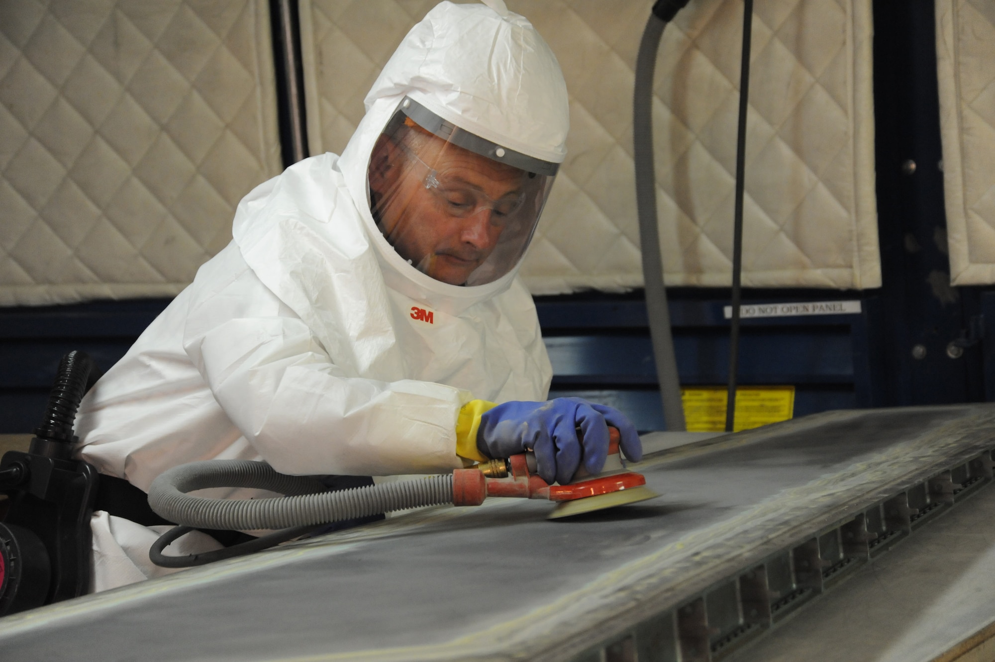 Ronnie Gadola, 574th Composite Repair Flight sheet metal mechanic, sands an F-15 torque box assembly in a new sanding booth in Bldg. 169. U. S. Air Force photo by Ray Crayton Jr.