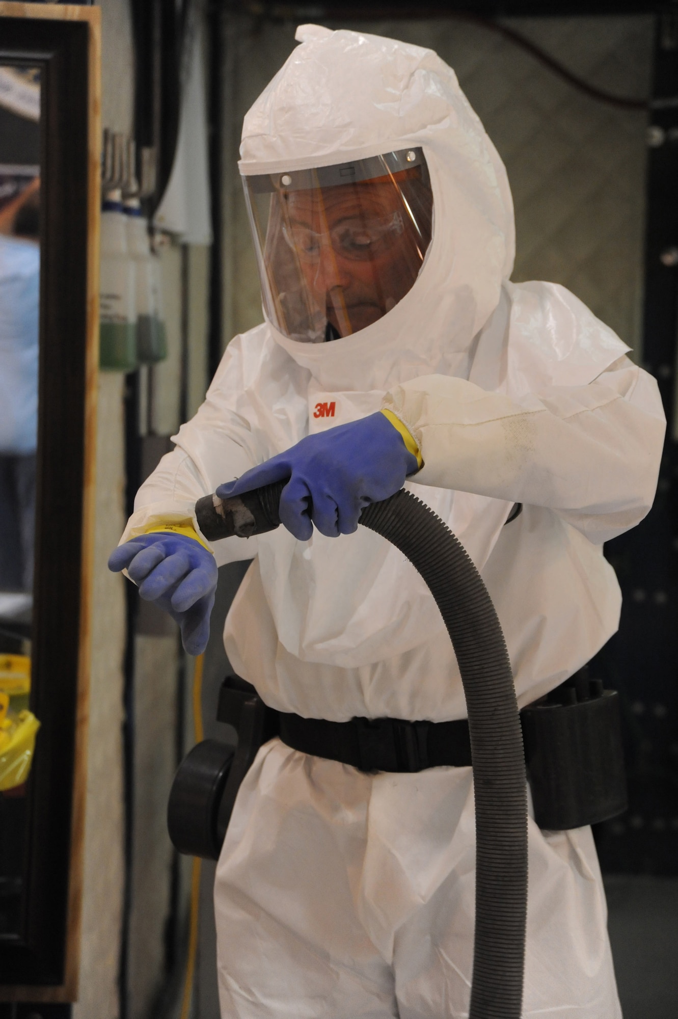 Ronnie Gadola, 574th Composite Repair Flight sheet metal mechanic, uses a HEPA vacuum to begin the decontamination process. U. S. Air Force photo by Ray Crayton Jr.