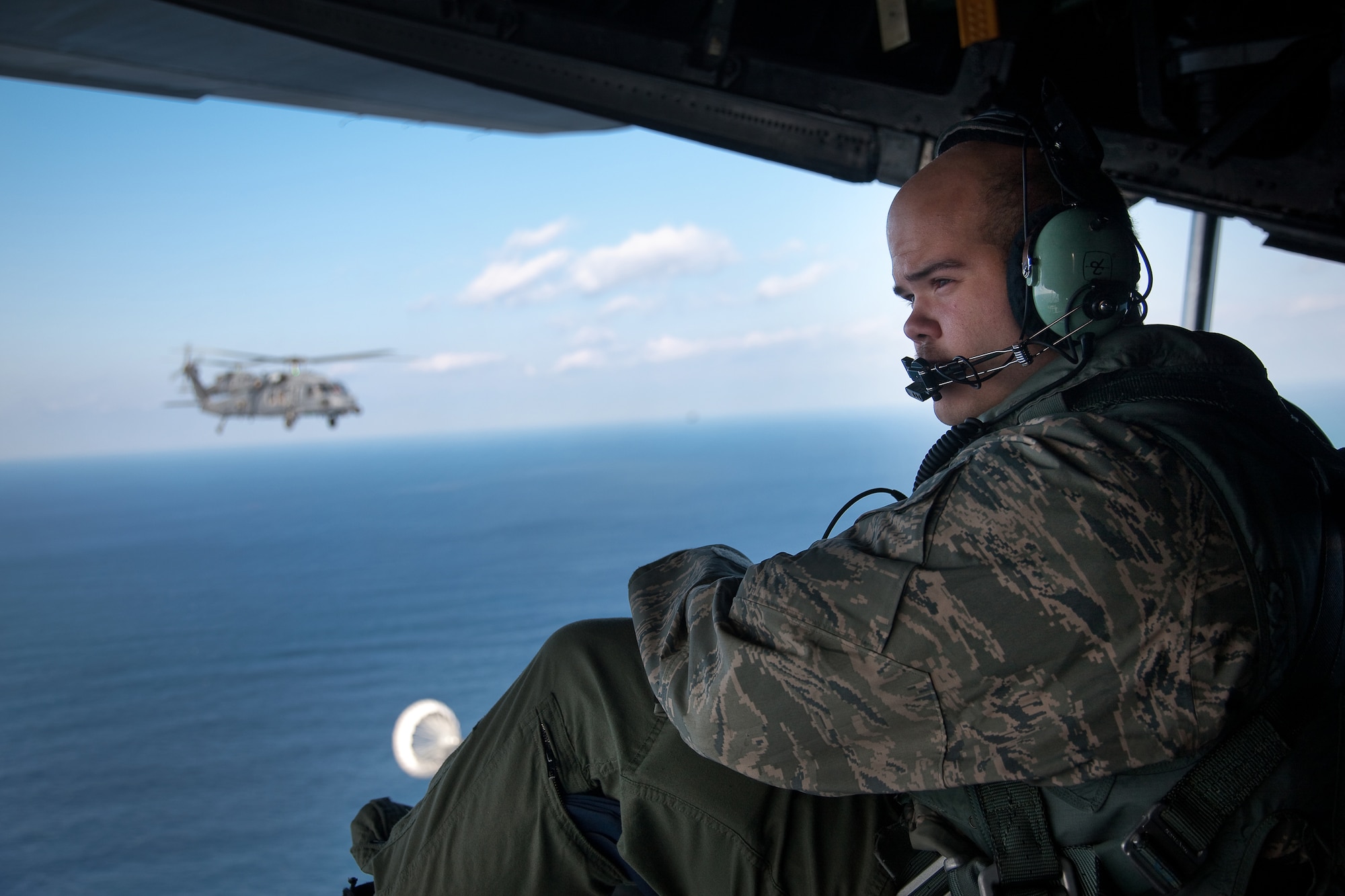 PACIFIC OCEAN -- Senior Airman Ramon Mortensen, a 17th Special Operations Squadron loadmaster, observes an HH-60 Pave Hawk helicopter from the 33rd Rescue Squadron during an aerial refueling March 18. The refueling missions are in support of humanitarian relief operations after an 8.9 magnitude earthquake and following tsunami that rocked Northeastern Japan March 11. (U.S. Air Force photo/Osakabe Yasuo) 
