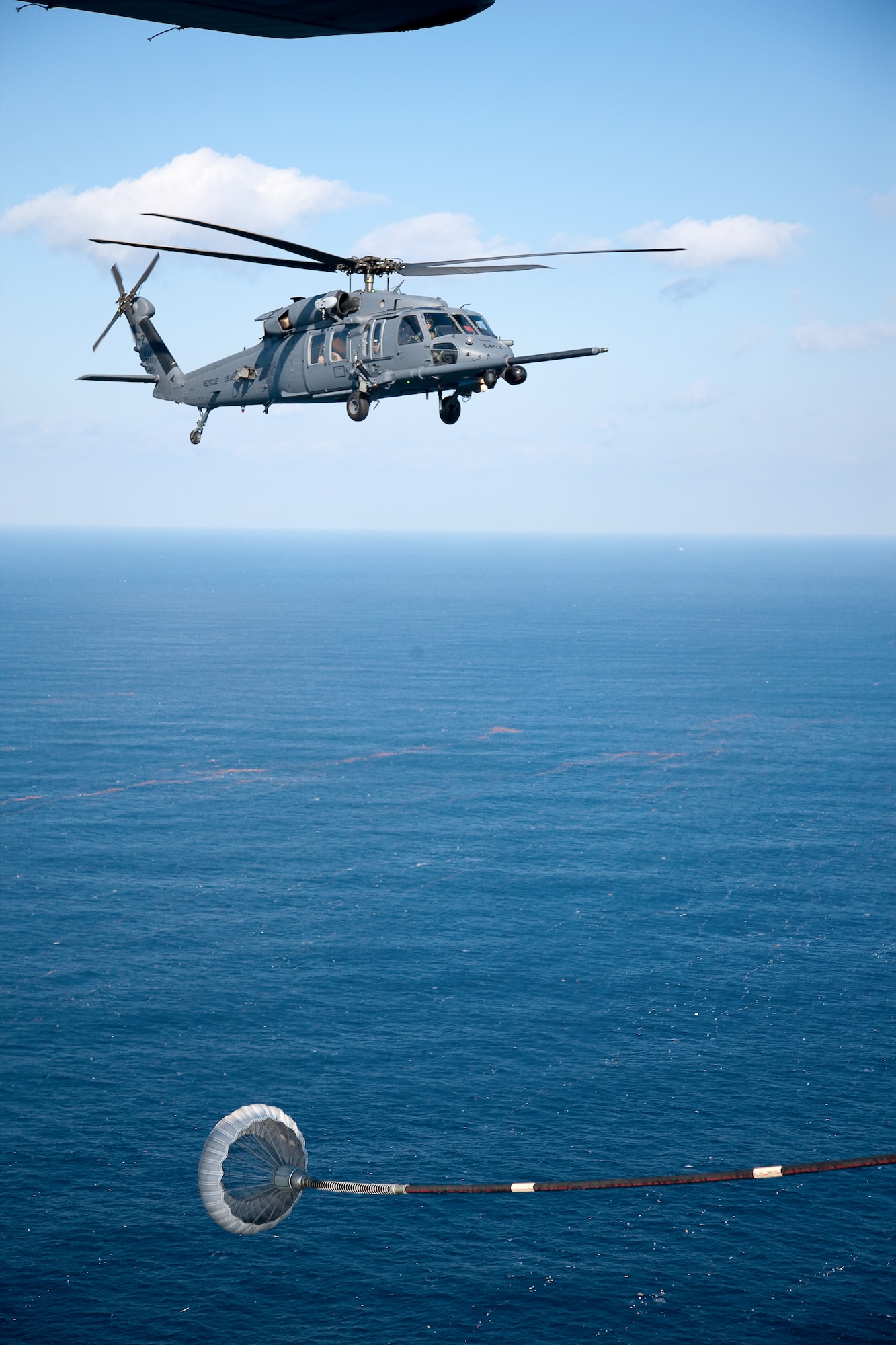 PACIFIC OCEAN -- An MC-130P Combat Shadow from the 17th Special Operations Squadron refuels a HH-60 Pave Hawk helicopter from the 33rd Rescue Squadron March 18. The refueling missions are in support of humanitarian relief operations after an 8.9 magnitude earthquake and following tsunami that rocked Northeastern Japan March 11. (U.S. Air Force photo/Osakabe Yasuo) 