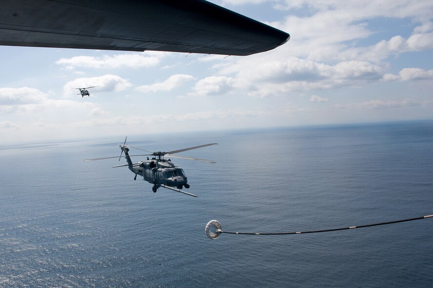 PACIFIC OCEAN -- An MC-130P Combat Shadow from the 17th Special Operations Squadron refuels two HH-60 Pave Hawk helicopters from the 33rd Rescue Squadron March 18. The refueling missions are in support of humanitarian relief operations after an 8.9 magnitude earthquake and following tsunami that rocked Northeastern Japan March 11. (U.S. Air Force photo/Osakabe Yasuo)