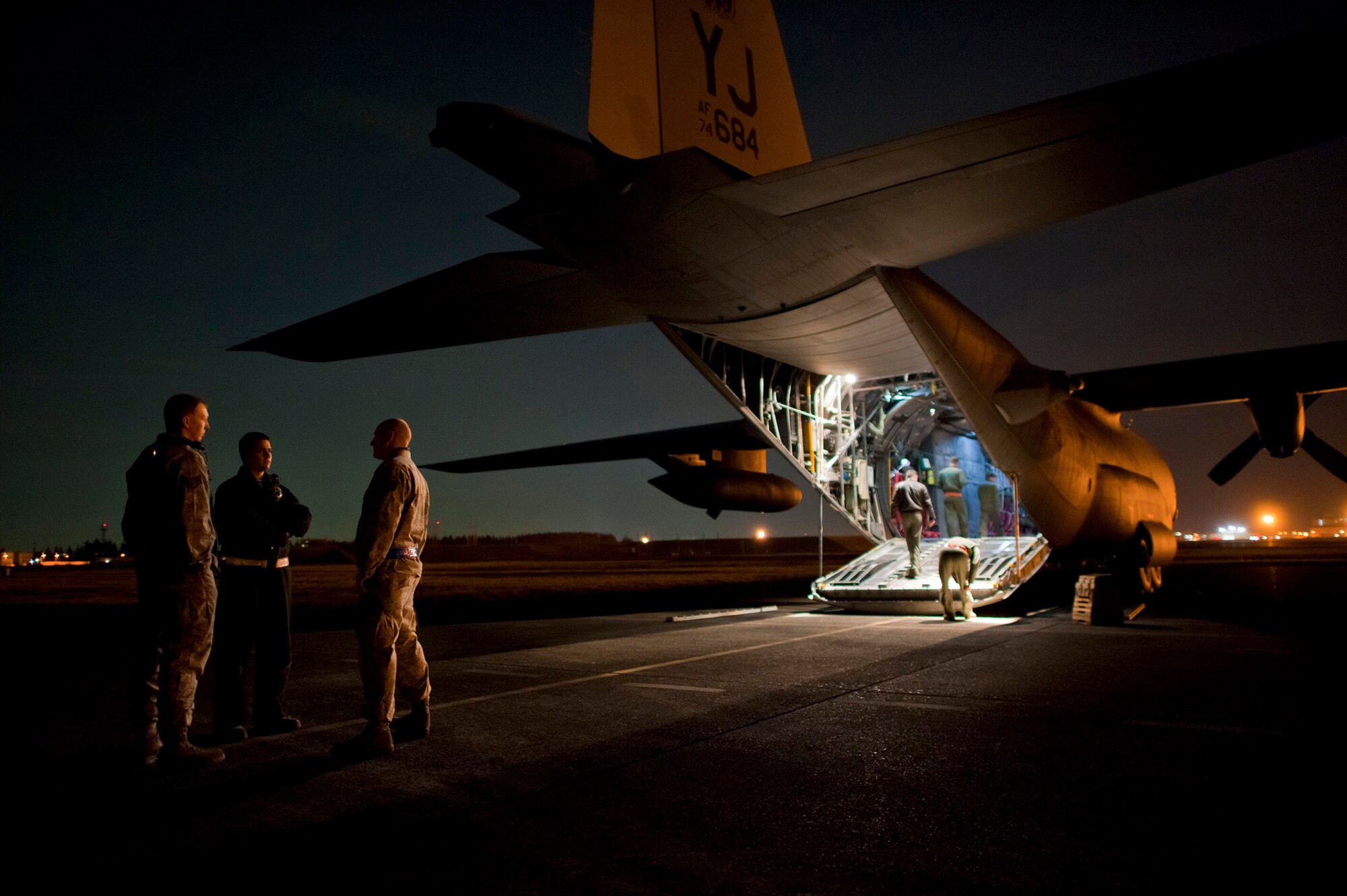 Maintainers from the 374th Aircraft Maintenance Squadron talk with loadmasters and flight engineers from the 36th Airlift Squadron while starting up a C-130 Hercules March 14, 2011, at Yokota Air Base, Japan. C-130s play a crucial role in disaster-relief operations because of their ability to land on dirt runways and other less-than-ideal landing conditions. (U.S. Air Force photo/Staff Sgt. Samuel Morse)