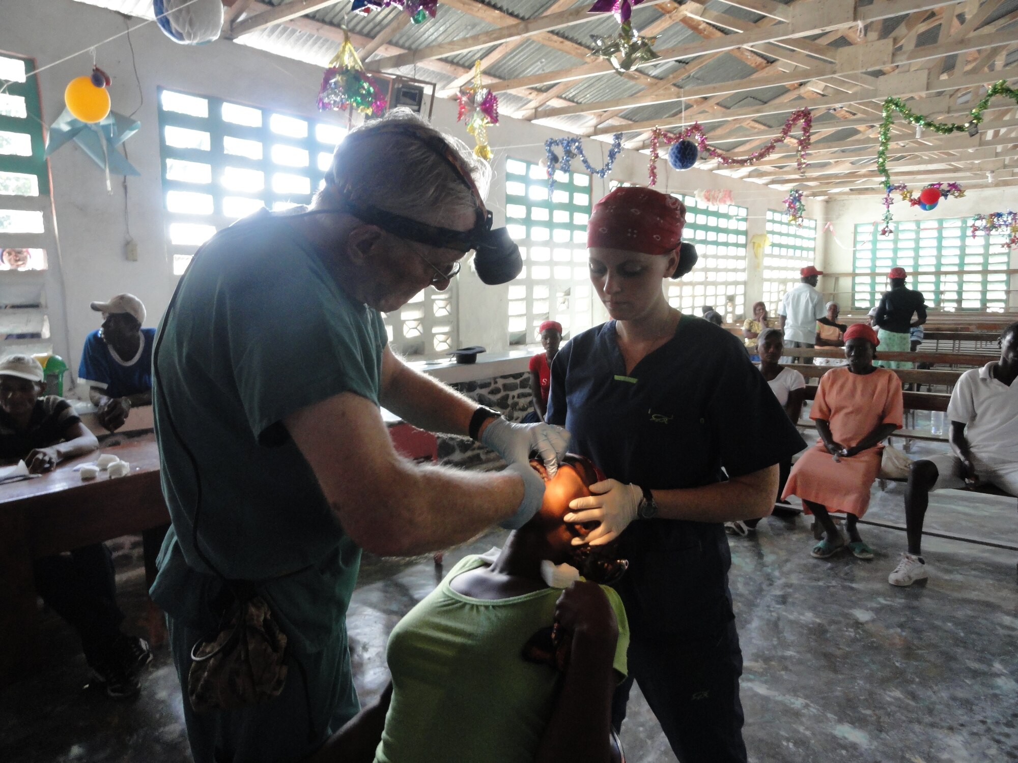 1st Lt. Carli Brown (far left) assists her father Lt. Col. (Dr.) Victor Brown and Dr. John Nystrom perform a dental procedure on a young Haitian boy near the Haitian capital of Port-Au-Prince. Both the Browns and Dr. Nystrom travel down to Haiti as part of the Weslyan Medical Fellowship to provide medical and dental relief to the Haitian people. (Courtesy photo) 