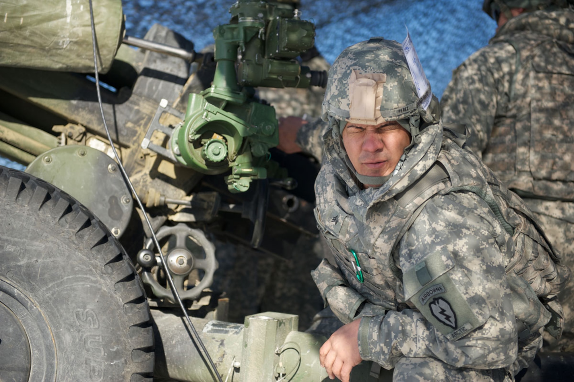 Sgt. Joe Perez, 3rd Section gunner, A Battery, 2nd Battalion, 377th Parachute Field Artillery Regiment, grimmaces while firing a M119A1 105-mm howitzer, March 9, at Joint Base Elmendorf-Richardson. Artillerymen from A Battery deployed to the field for live fire exercises. (U.S. Air Force photo/David Bedard)