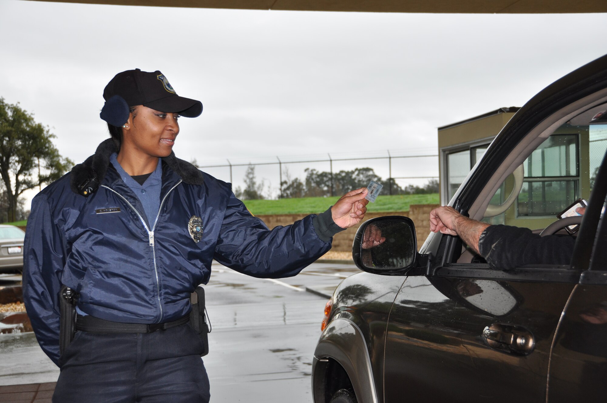 Crystal Houston checks an identification card March 10 at the gate. 