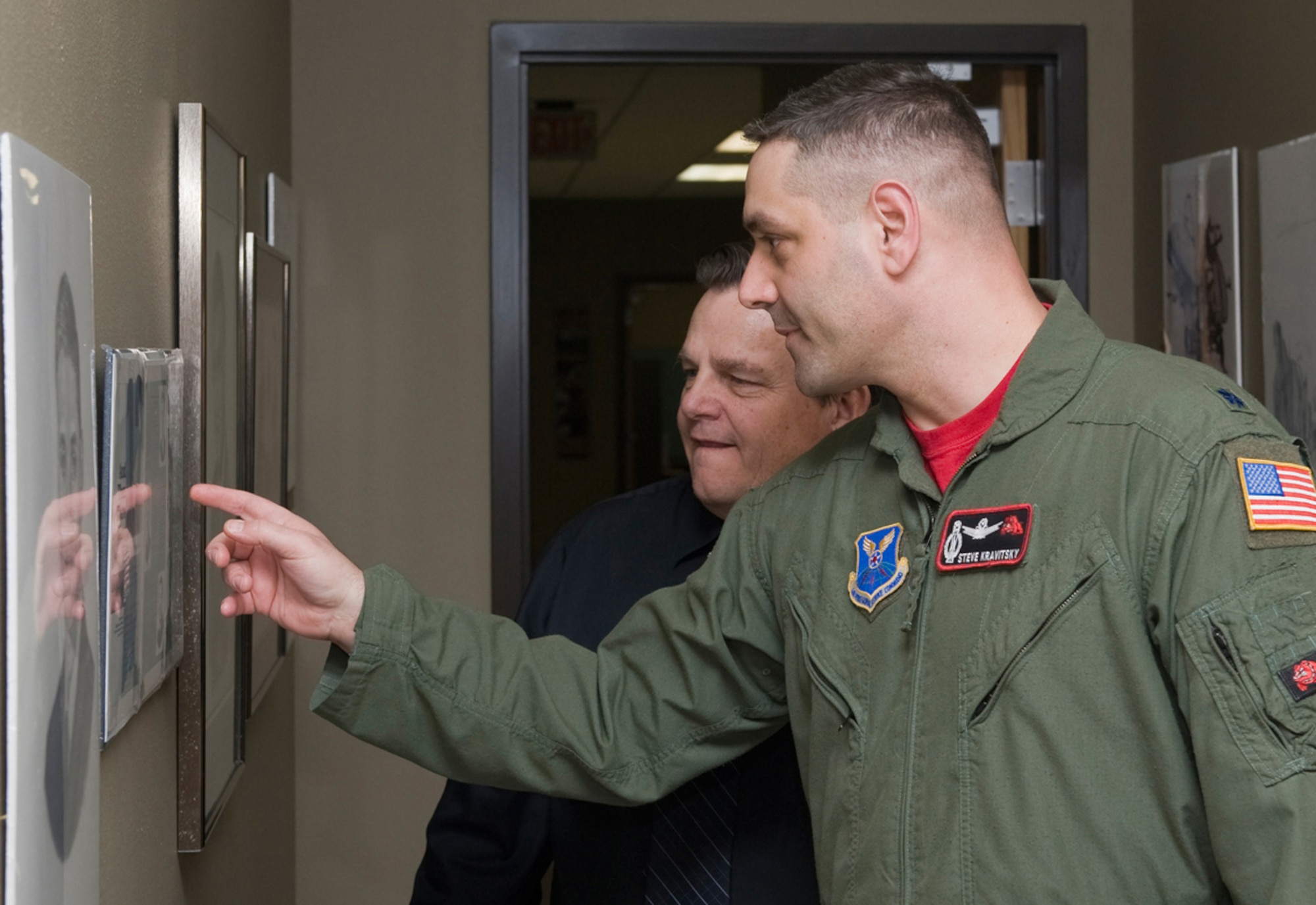 Bob Stillwell, 341st Missile Wing public affairs graphic artist, and Lt. Col. Stephen Kravitsky, 12th Missile Squadron commander, look at protraits Mr. Stillwell drew in 1990 for Airman Magazine when he was a technical sergeant assigned to the Air Force Orientation Group. Among the portraits, was then Sgt. Kravitsky, named one of the 12 Outstanding Airmen of the Year for 1989. Mr. Stillwell later gave the commander the original pencil drawing, which Colonel Kravitsky will likely give to his parents, he said. Mr. Stillwell found the drawing and magazine while he was preparing some of his artwork for an art show featuring his work at the base arts and crafts center March 11. (U.S. Air Force photo/Beau Wade)