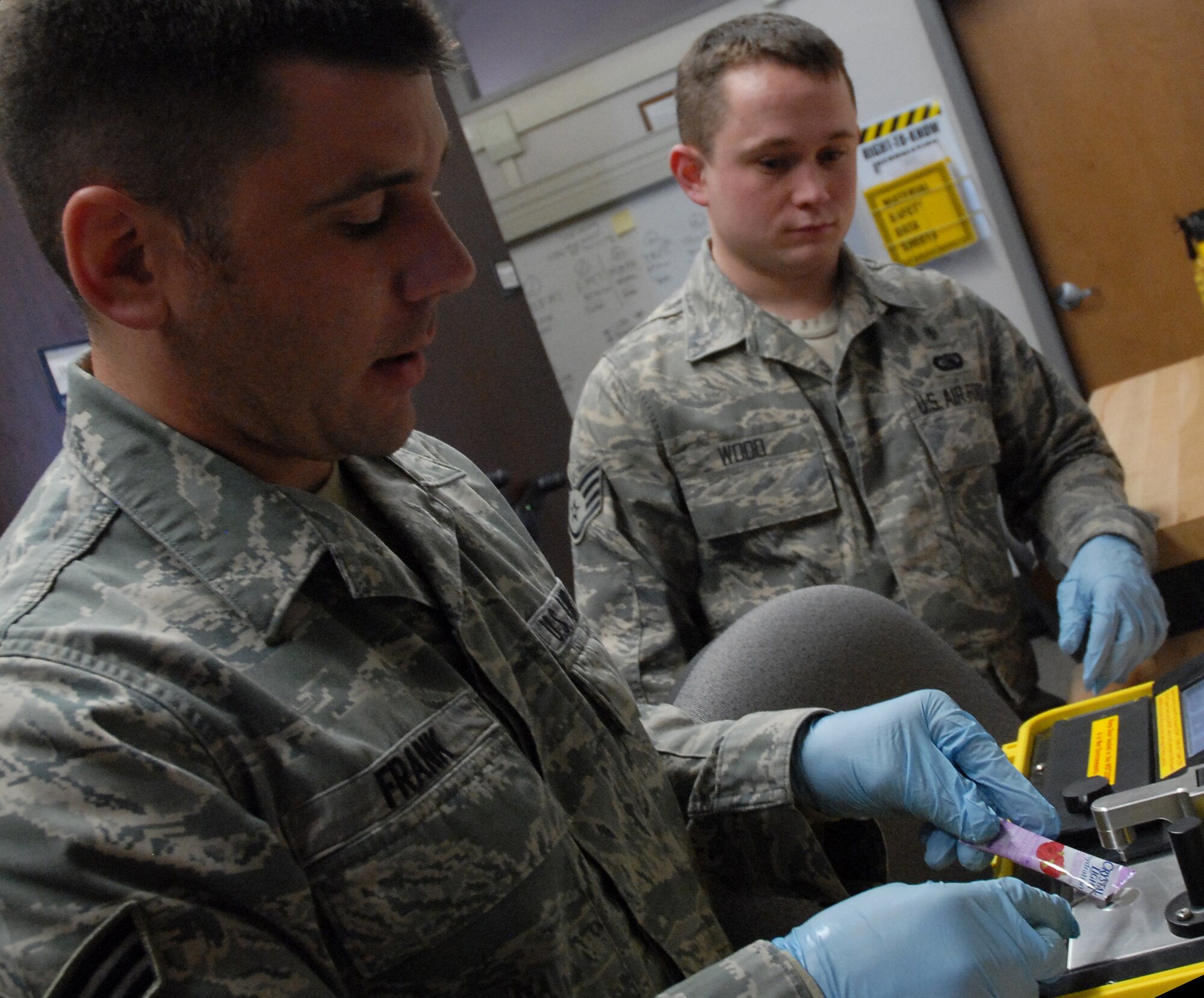 Senior Airman Rich Frank, 341st Medical Operations Squadron bioenvironmental engineer, demonstrates the capabilities of bioenvironmental equipment to identify substances March 4 at the bioenvironmental building. Staff Sgt. James Wood, observing, is also a bioenvironmental engineer with the 341st MDOS and is Airman Frank's supervisor. (U.S. Air Force Photo/Staff Sgt. Dillon White)