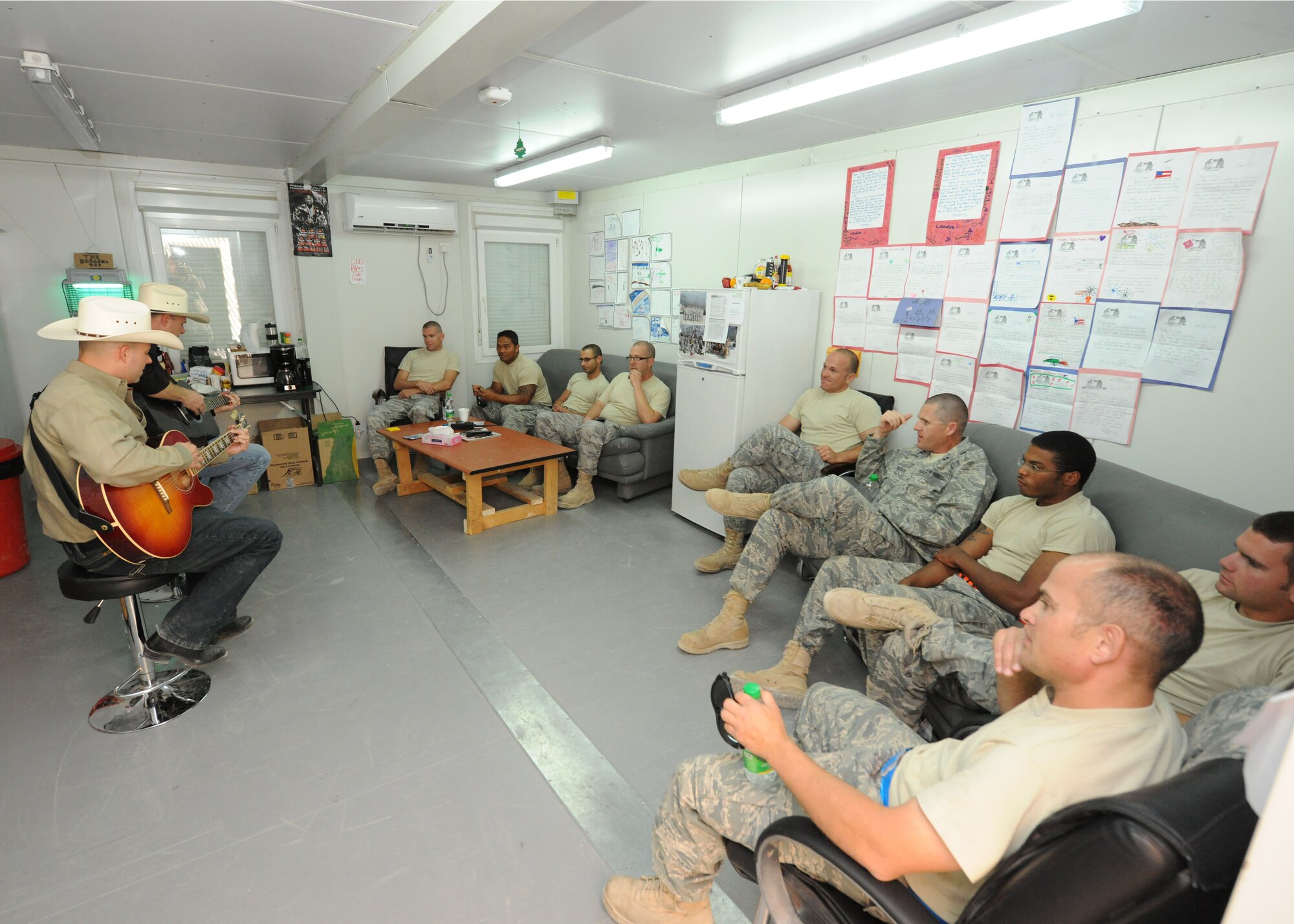 The U.S. Air Forces Central Band, Wild Blue Country, plays for Airmen at an undisclosed location in Southwest Asia. Two Wild Blue Country members provided "acoustic" performances in eight shops on the base, including a stop at the supply warehouse where some impromptu lessons broke out. (U.S. Air Force photo by Master Sgt. Karl Bradley)